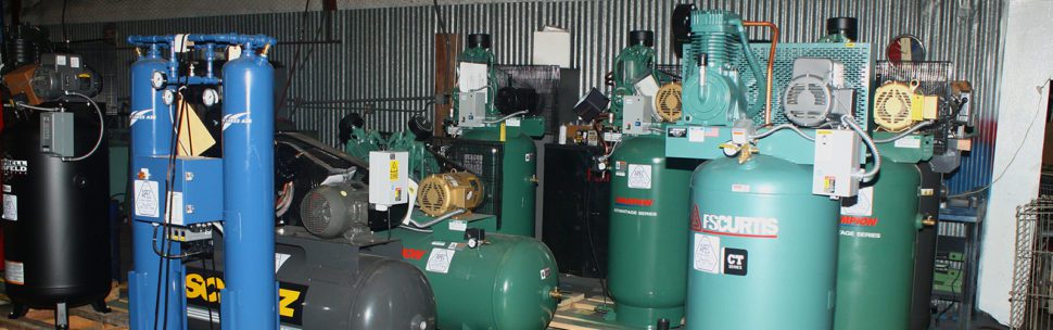 Row of industrial air compressors including FS Curtis and Champion models in an Oklahoma City body shop
